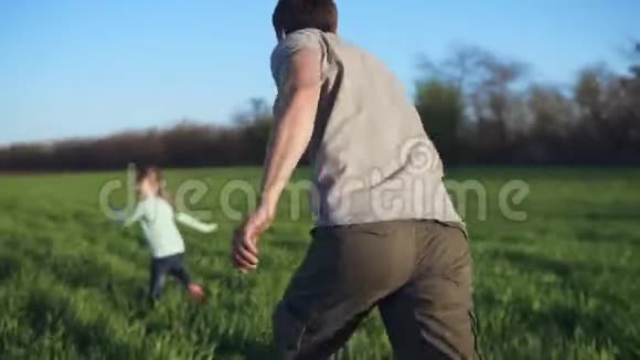 幸福的家庭在阳光明媚的日子里在草地上休息父亲和他的小女儿玩追赶游戏广阔的绿色领域视频的预览图