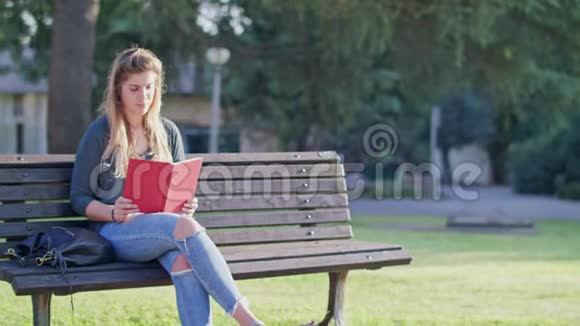 年轻女子坐在长凳上听着留言环顾四周视频的预览图