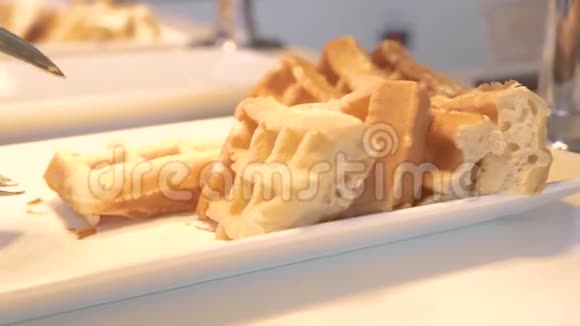 传统的比利时华夫饼躺在酒店餐厅的自助餐白餐盘上早上提供甜烤华夫饼视频的预览图