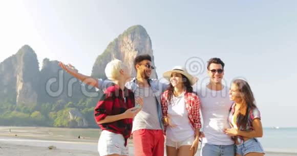 人们在沙滩上聊天在手机上拍照年轻男女游客交流视频的预览图