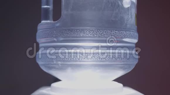 黑色背景下冷却器中水瓶的特写行动有气泡的冷却器中的最纯净的水被视频的预览图