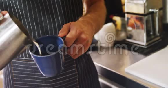 4k咖啡馆的男侍者将牛奶倒入杯子视频的预览图