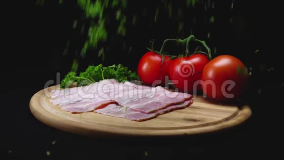 在黑色隔离背景上的木制烹饪板上特写食材框架手里拿着绿色香芹视频的预览图