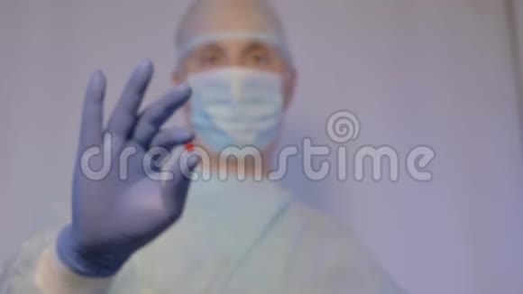 医生是一位戴着医用口罩的外科医生给病人看他应该吃的药丸他举起大拇指视频的预览图