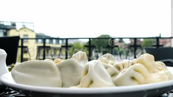 热气腾腾的卡其利饺子正躺在靠近户外餐厅的白色盘子里视频的预览图