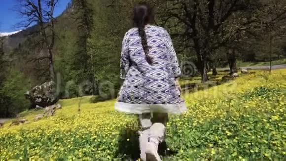 一个年轻的女人在夏天沿着田野走过花丛视频的预览图