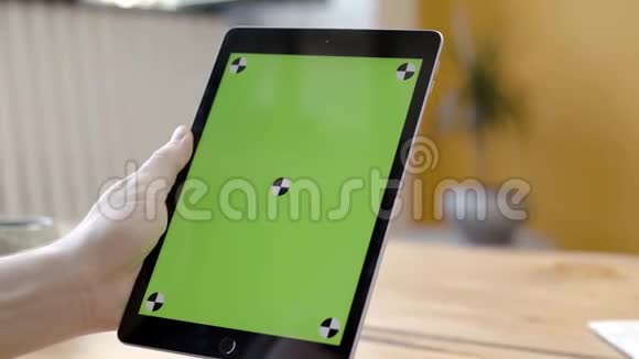 在绿色屏幕上用平板电脑敲击的人库存录像双手握住并按在手上的特写镜头视频的预览图
