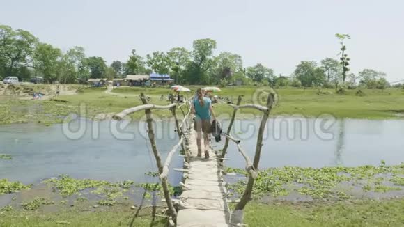 女孩沿着木桥走过河流亚洲尼泊尔视频的预览图