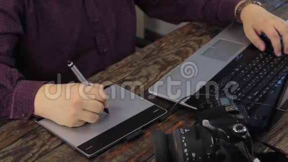 特写镜头设计师在图形平板上工作在电脑手提电脑上视频的预览图