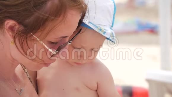 妈妈带着一个孩子在户外海滩吃西瓜视频的预览图