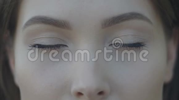 年轻女子的特写镜头蓝眼睛配上浅色的户外化妆视频的预览图