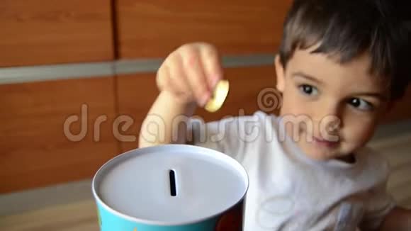 可爱的两岁存钱把硬币放进金属银行视频的预览图