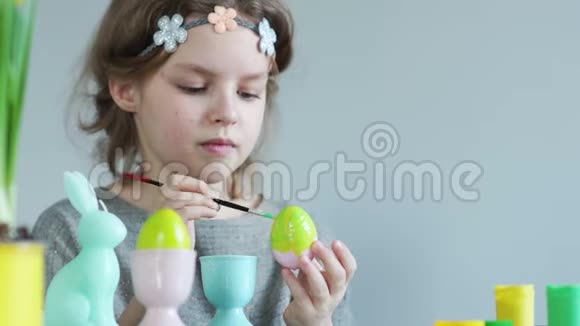 可爱的小女孩画复活节彩蛋用石灰色刷刷复活节概念视频的预览图