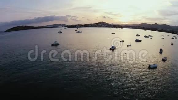 伊比萨美丽的日落地平线隐藏在群山船只和帆船漂浮的游艇后面视频的预览图