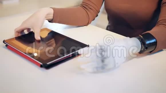 一个有机械手臂的女人正在操作平板电脑视频的预览图