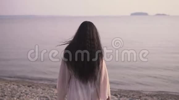 美丽的女孩在沙滩上走向大海微笑着慢动作视频的预览图
