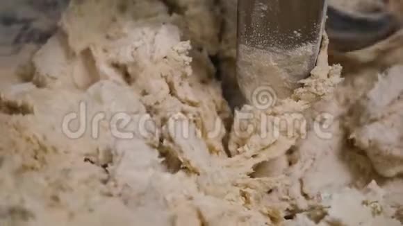 在与面粉混合的搅拌机中特写揉面团库存录像在面团中加入少量面粉视频的预览图