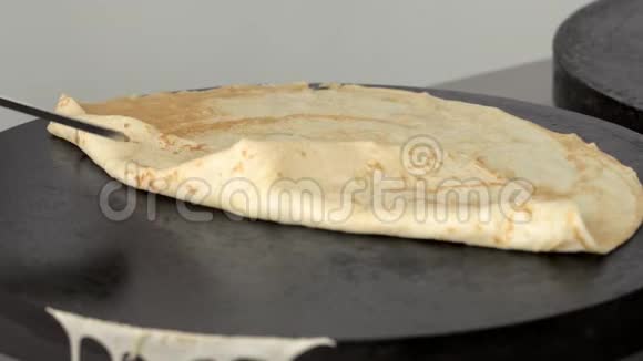 厨师把烤好的煎饼折叠起来慢慢地从盘子里取出视频的预览图