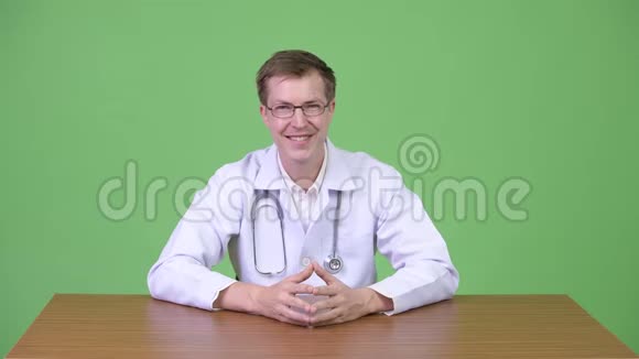 快乐男医生坐在微笑和手指向上视频的预览图