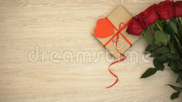 男性手拿订婚戒指在木制背景和礼品盒玫瑰视频的预览图