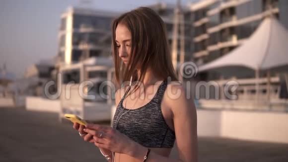 一个穿着运动胸罩的长发女孩的惊人造型在移动电话中滚动页面浅色皮肤风易起浪视频的预览图