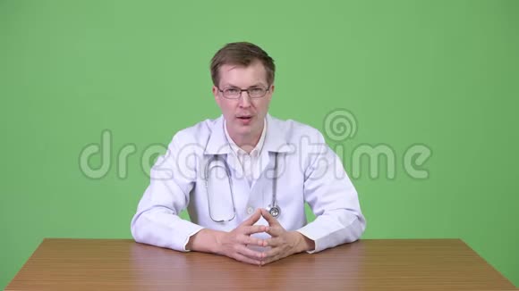 年轻自信的男医生坐着说话视频的预览图