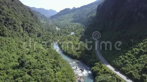 鸟瞰绿色峡谷与河流和公路视频的预览图
