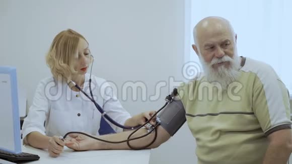 高级医生在心脏病医生的接待处检查脉搏视频的预览图