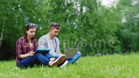 大学生一起在大自然中学习享受你的平板电脑和笔记本电脑视频的预览图