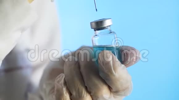 注射器针穿过玻璃瓶的橡胶塞从玻璃壶中填充注射器视频的预览图