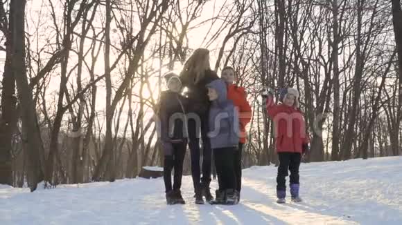 冬天公园里妈妈和儿子们手挽手拍照视频的预览图