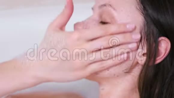 女人在浴室里的脸上涂了一层擦洗面的特写白色背景视频的预览图