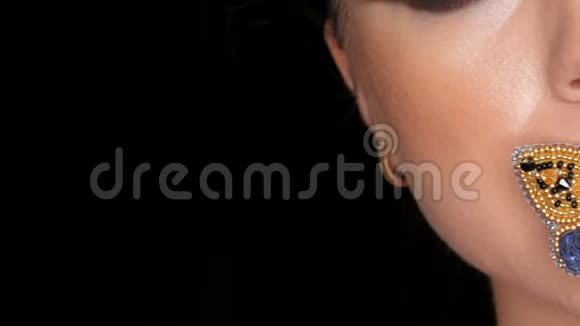 一个漂亮的年轻女孩模特的肖像她的眼睛化妆时髦嘴唇上有一只蝴蝶摆在面前视频的预览图