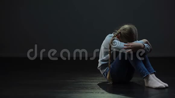 孤独的女孩坐在黑暗的房间里环顾四周等待孤儿的家人视频的预览图