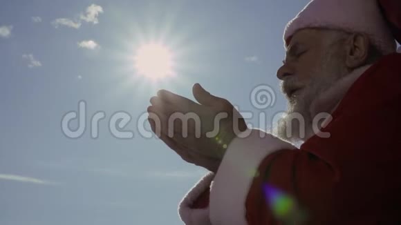 圣诞老人用手在太阳下吹雪动作缓慢视频的预览图