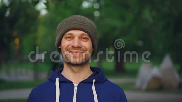 特写慢镜头肖像快乐运动员微笑着看着镜头站在公园春天积极主动视频的预览图