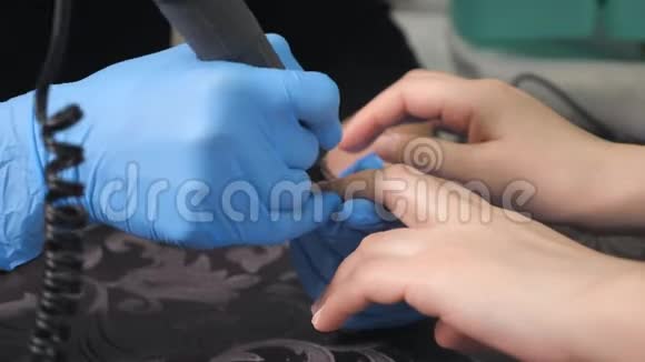 美甲师在美甲沙龙里对女孩的指甲进行修指甲的程序和指甲的延伸视频的预览图