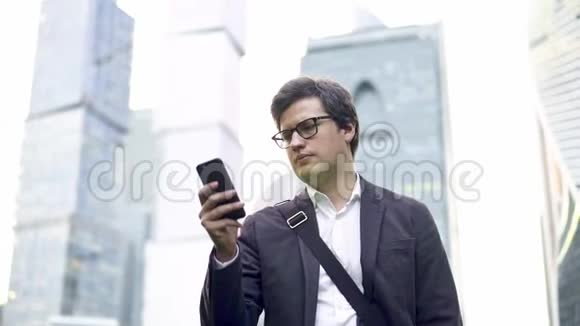 一位戴着眼镜的商人在莫斯科的智能手机屏幕上视频的预览图