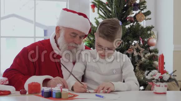 圣诞老人看起来就像小男孩用颜色装饰工艺品视频的预览图