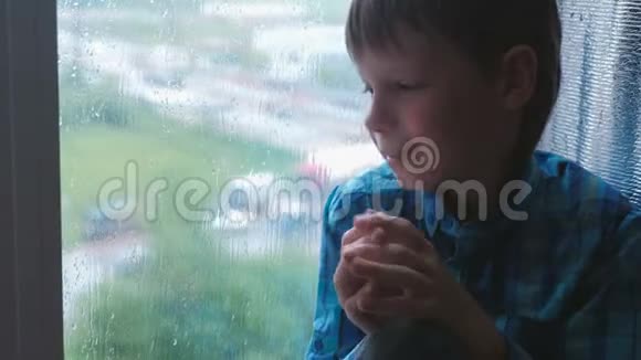 哭泣的男孩在雨中看着窗外很伤心视频的预览图