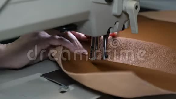 人造革缝制工艺缝纫机的针在运动中女裁缝在缝纫中缝制黑色皮革视频的预览图