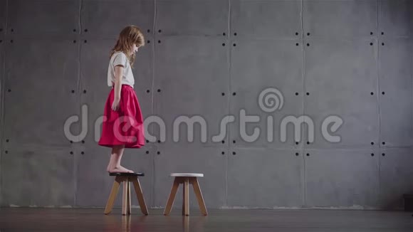 小女孩走在小椅子上慢动作视频的预览图