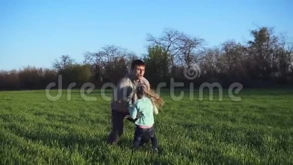 一个年轻的父亲带着一个女儿在空旷的农村到处闲逛一个男人把一个女孩抛在空中挠她痒痒视频的预览图
