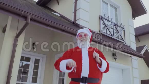 圣诞老人刚买了一栋新房子并在相机上显示钥匙视频的预览图