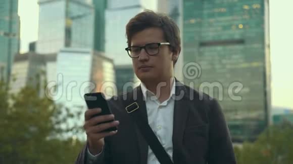 穿着西装用智能手机走路的严肃青年莫斯科视频的预览图
