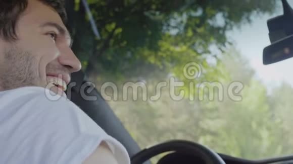 英俊的男人微笑着双手打手势坐在车里视频的预览图