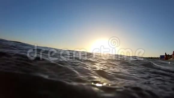 日落时靠近公共海岸近景的海水慢动作视频的预览图