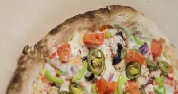 在轻木背景下旋转半味披萨与培根和蔬菜的特写镜头垂直屏幕视频的预览图