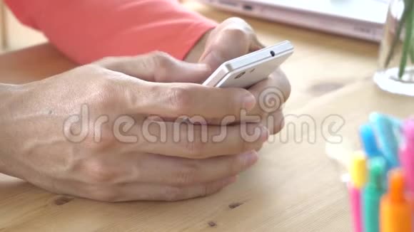 玫瑰粉色T恤商人聊天打字或玩智能手机视频的预览图