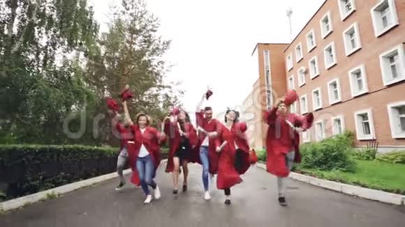 快乐的毕业学生手里拿着毕业证书挥舞着灰泥板大笑起来高等教育视频的预览图